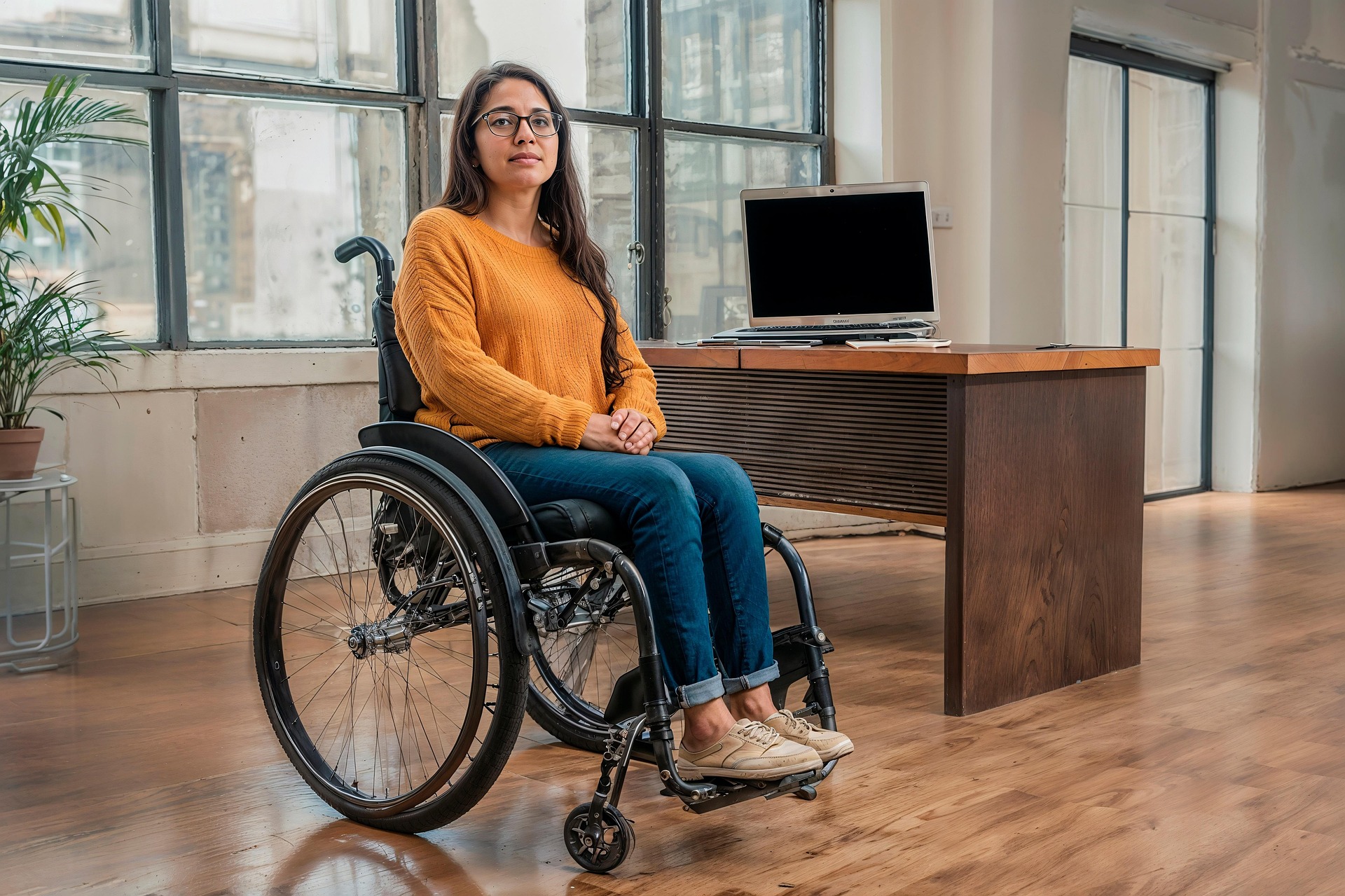 Inclusive and Adaptive Technology for Employees and Businesses in Wiltshire, Hampshire and Dorset Woman at a desk in wheelchair - Assistive Technology Assessment service for Companies